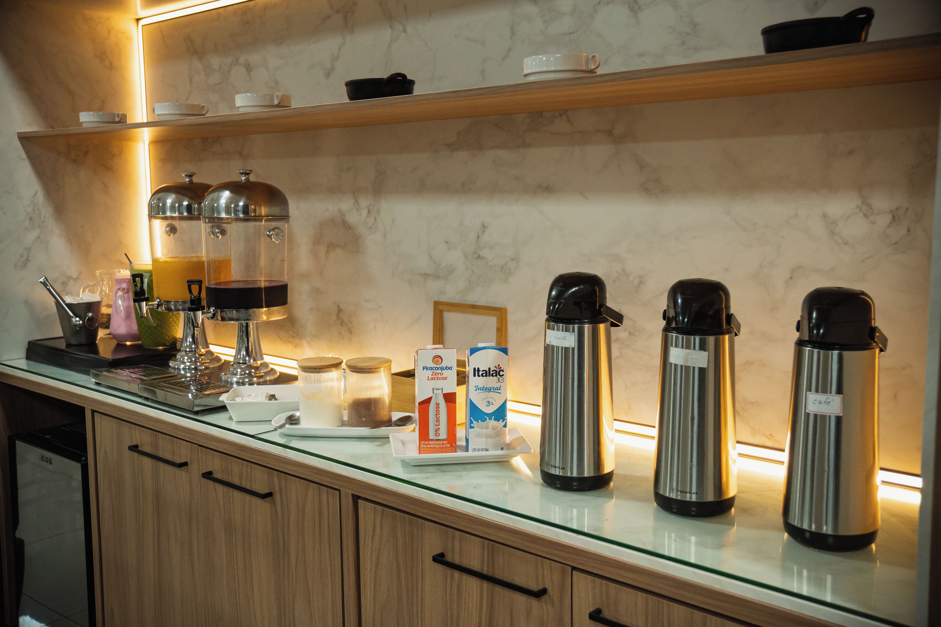 A kitchen counter with coffee makers, a milk carton, and a coffee pot.
