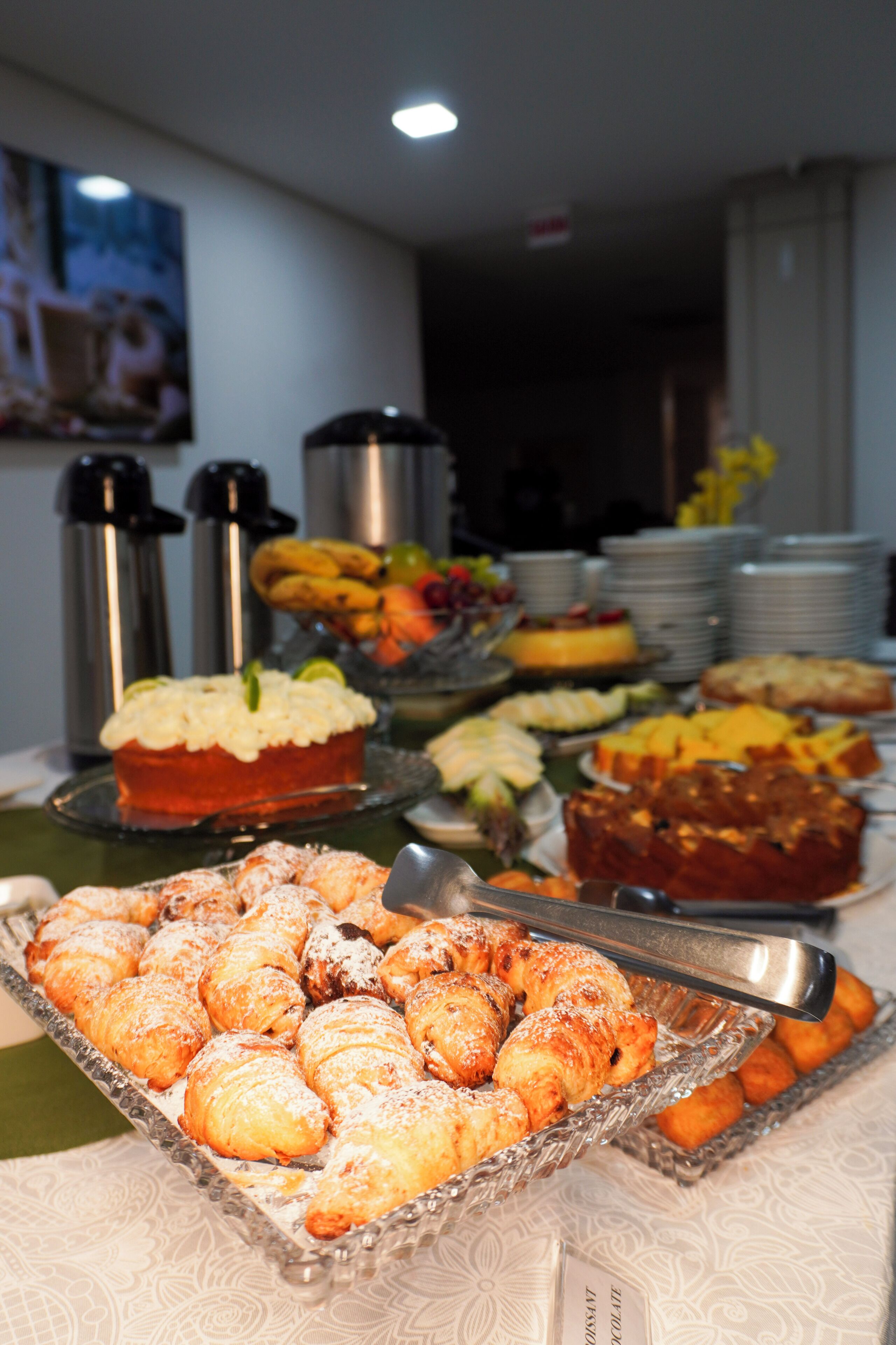 A buffet with various food items including pastries, fruits, and desserts.
