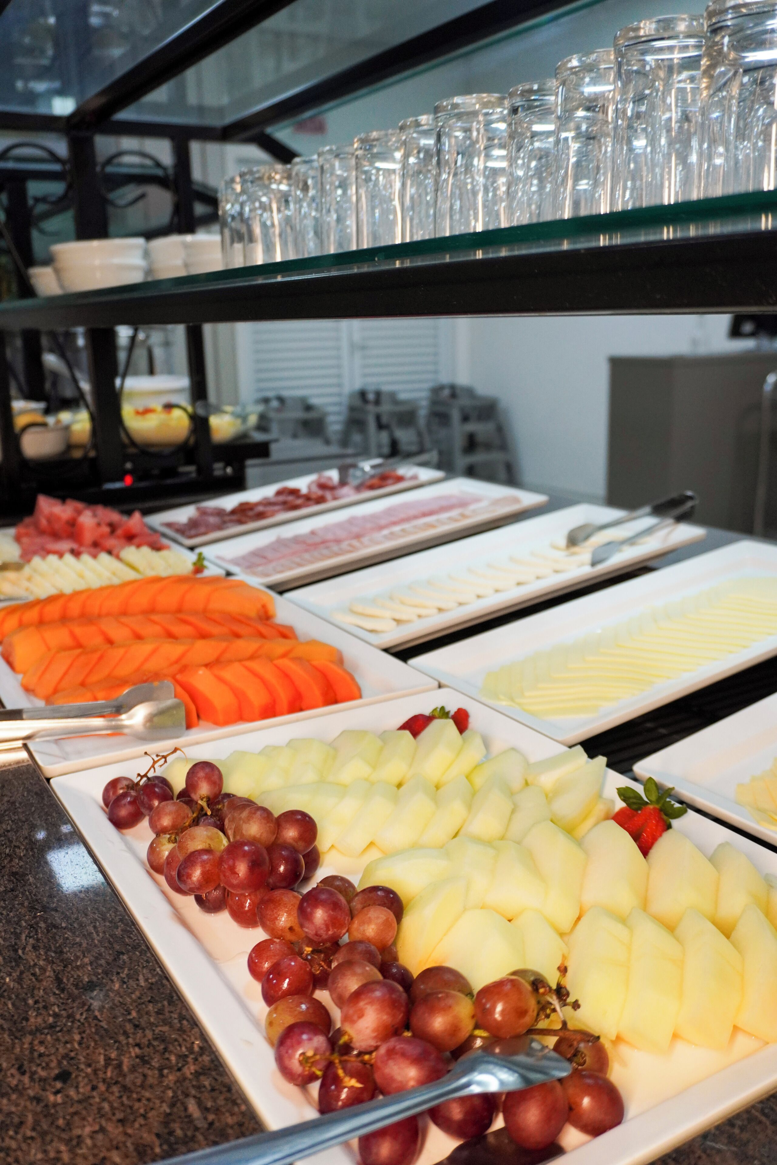A buffet with various food items including fruits and cheeses.