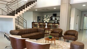 Un salón moderno con un sofá, sillones, una mesa de centro y una alfombra.