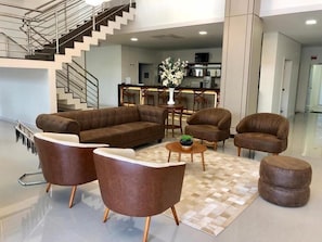Un espace de vie moderne comprenant un canapé, des fauteuils, une table basse et un tapis.