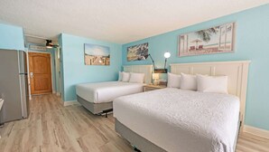 A hotel room with two beds, a refrigerator, a wooden door, and a beach-themed wall art. - Renovated Oceanview Studio Steps from Ocean Annies (Myrtle Beach)