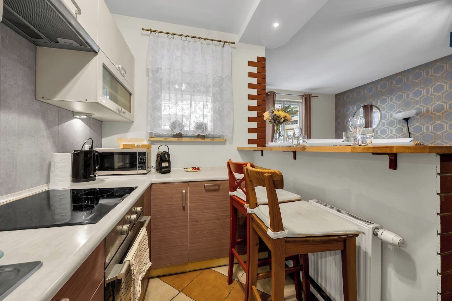 Une cuisine compacte équipée d’un four à micro-ondes, d’une bouilloire et d’un petit coin repas avec une chaise et une table.