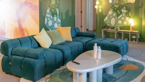 A teal sectional sofa with a white coffee table and a patterned rug. - Relaxing 4BR with Pool, Game Room & BBQ Fun (Tucson)