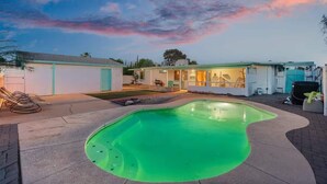 A backyard with a swimming pool, a house, and a garage. - Relaxing 4BR with Pool, Game Room & BBQ Fun (Tucson)