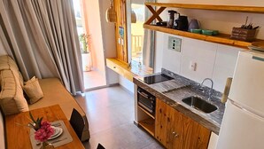 A modern kitchen with a wooden countertop, built-in oven, and a sink. - Beachfront house with sunset views (São Miguel do Gostoso)