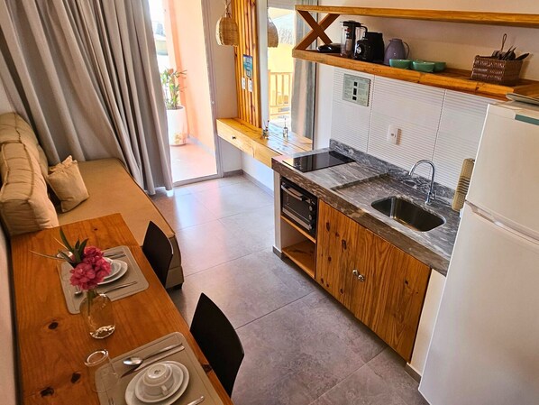 A modern kitchen with a built-in oven, a sink, and a wooden countertop.