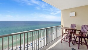 A balcony with a view of the ocean and beach, featuring a table and two chairs. - Majestic Beach Towers 1-1510 (Panama City Beach)
