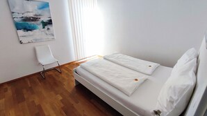 A room with a bed, a chair, and a painting on the wall. - Seeidylle Winkler vacation apartment directly on Lake Ossiach with its own bathing beach (Bodensdorf)