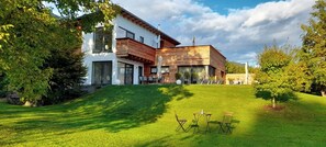 A modern two-story house with a sloped roof, large windows, and a well-maintained lawn. - Seeidylle Winkler vacation apartment directly on Lake Ossiach with its own bathing beach (Bodensdorf)