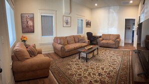 A spacious living room with two sofas, a coffee table, and a patterned rug.