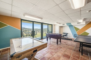 A recreational room with a foosball table, a ping pong table, and a shuffleboard table. - NEW! Beachfront|Resort Style Pool|Views! (Port Aransas)