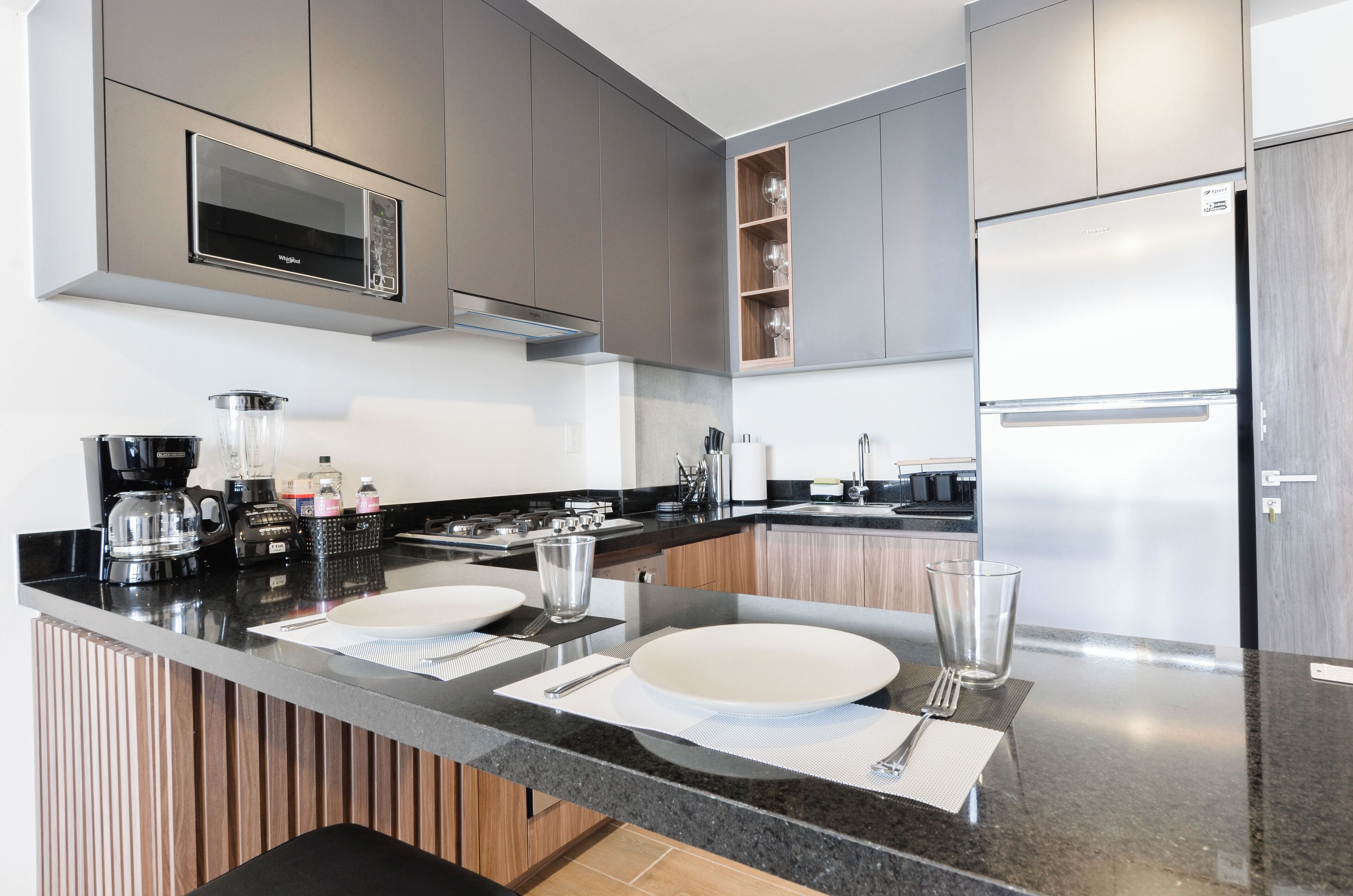 A modern kitchen with stainless steel appliances, a built-in microwave, and a double sink.