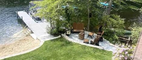 A view of a backyard with a patio, a small deck, and a grassy area.