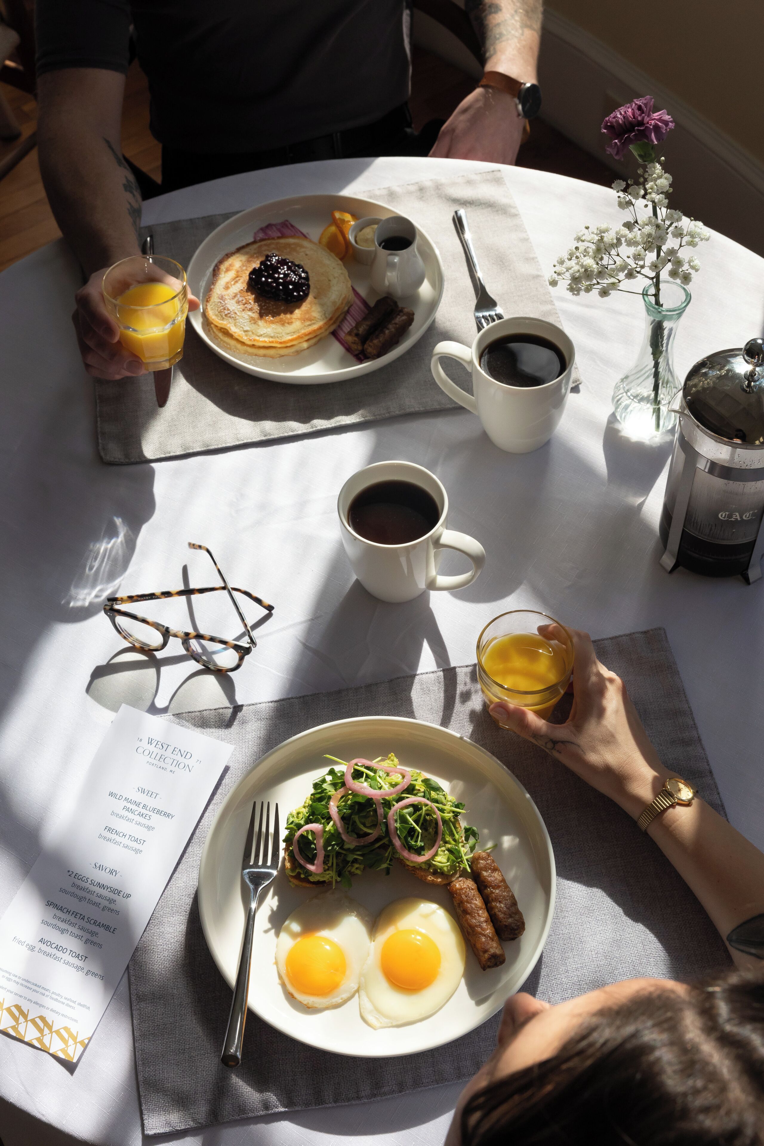 A breakfast setting with plates of food, a coffee cup, and a menu.