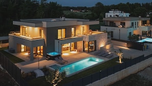A modern two-story house with a swimming pool, outdoor seating, and a well-lit patio area. - Designer Beach Villa Limes - Pool, Spa & Games (Funtana)