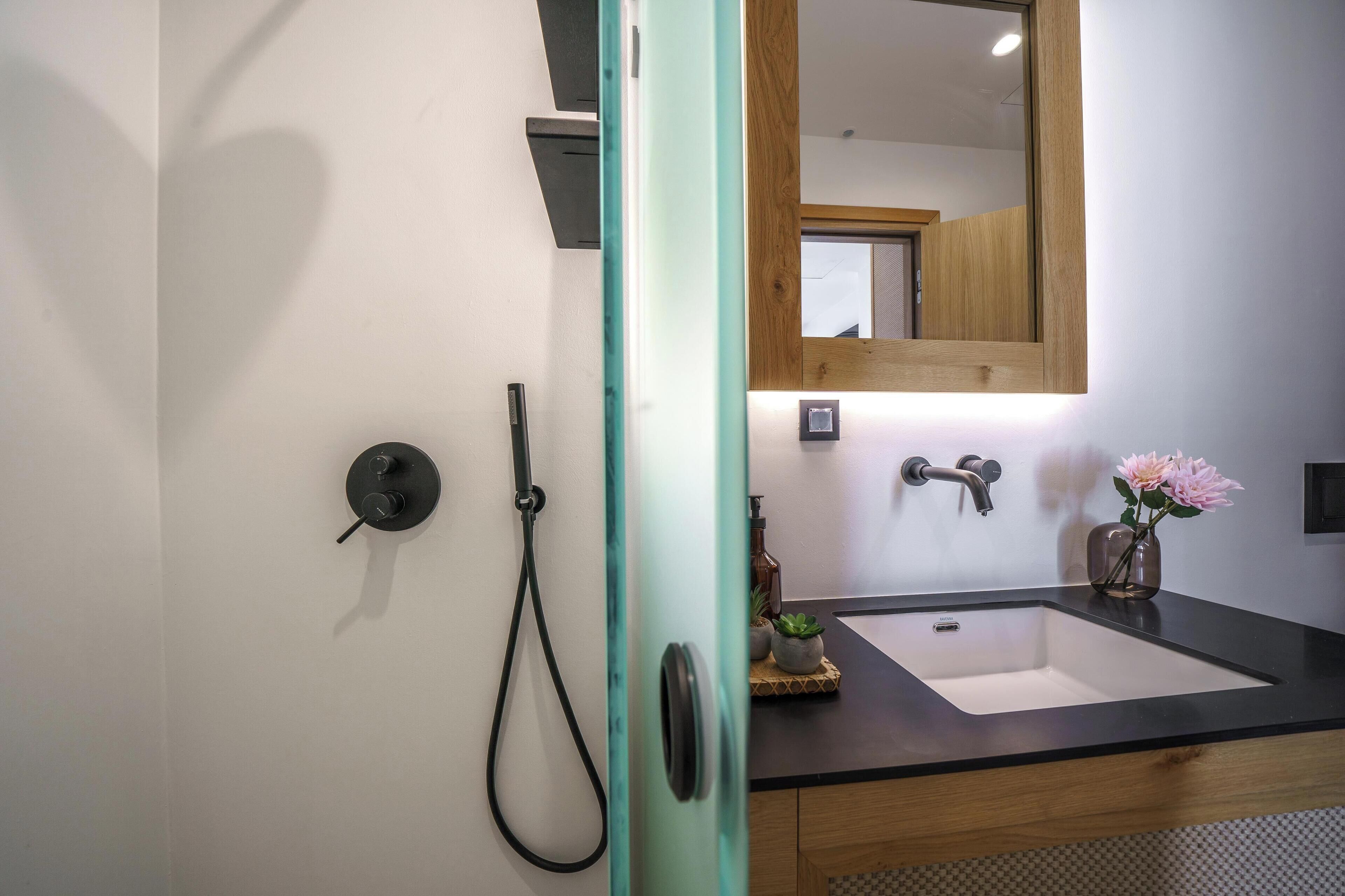 Une salle de bain avec un lavabo blanc, un meuble en bois et un miroir.