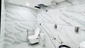Ein modernes Badezimmer mit Toilette, Mülleimer und Waschbecken.