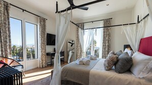 A bedroom with a bed, curtains, a desk, and a chair.