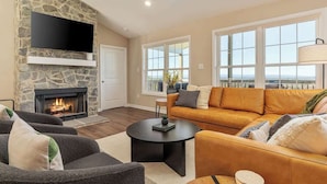 A living room with a stone fireplace, a flat-screen TV, a sofa, and a coffee table. - Luxury Mountain Retreat w/ Valley Views, Hot Tub (Front Royal)