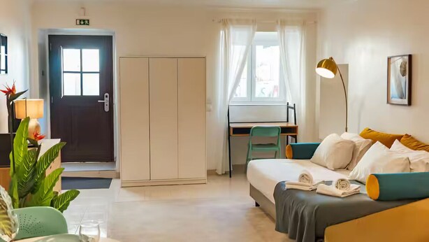 Una habitación de hotel con cama, escritorio, silla, armario y puerta.