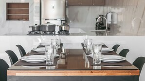 Een moderne keuken met een centraal eiland, voorzien van een kookplaat en pannen.