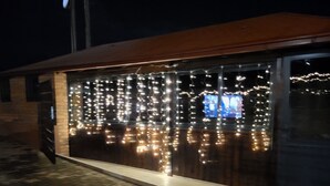 A building with a brick facade and a large glass window adorned with string lights. - Moding apartmans (Dobroshane)
