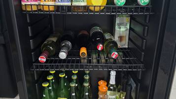 A refrigerated display case with various beverages including juices, beers, and wines.