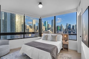 A modern bedroom with a large bed, a nightstand, and a view of a city skyline through floor-to-ceiling windows. - FIFA World Cup Art Stay | Free Parking & Pool (Miami)