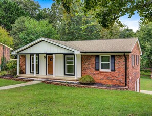 A single-story brick house with a front porch, a small front yard, and a mailbox. - Cozy Home in Hickory (Hickory)