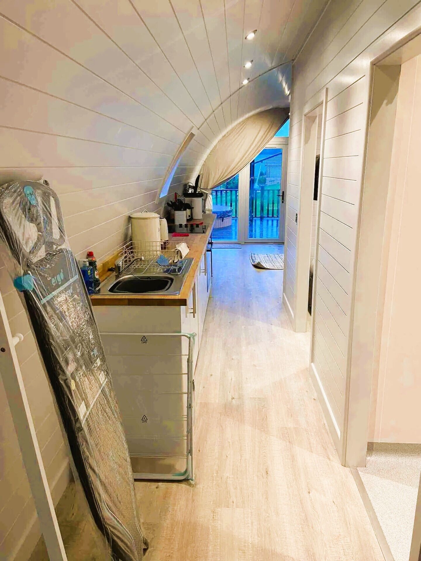 A narrow, modern kitchen with a built-in oven and a large window.