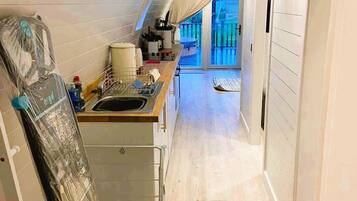A narrow, modern kitchen with a built-in oven and a large window.