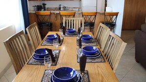 A dining area with a wooden table set for six, surrounded by wooden chairs. - Condo #308 with beautiful sunset view from your balcony overlooking the ocean (Lincoln City)
