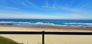 A beach view with waves, a sandy shore, and a clear sky. - Condo #202 with beautiful sunset view from your balcony overlooking the ocean (Lincoln City)