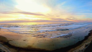 Een strand met golven en een zonsondergang.