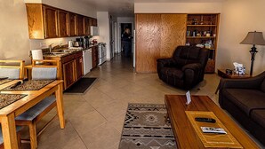 A living room with a sofa, coffee table, and a dining area with a table and chairs. - Condo #204 with beautiful sunset view from your balcony overlooking the ocean (Lincoln City)