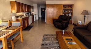 A living room with a sofa, coffee table, and a dining area with a table and chairs. - Condo #204 with beautiful sunset view from your balcony overlooking the ocean (Lincoln City)