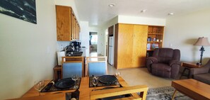 A compact living space with a dining area, kitchen, and seating area. - Condo #108 with beautiful sunset view from your balcony overlooking the ocean (Lincoln City)