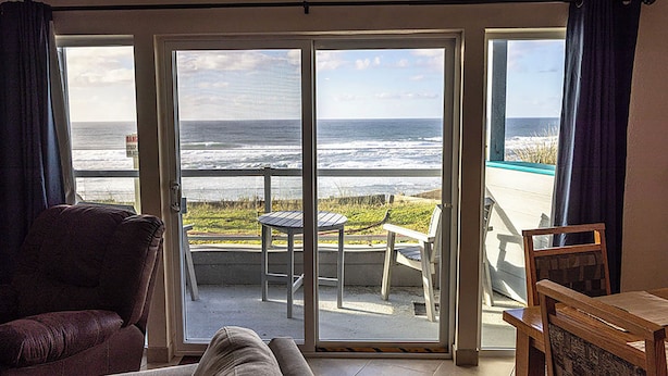 Ein Zimmer mit einer Schiebetür und einem Balkon mit Meerblick.