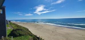 Ein Strand mit freiem Blick auf den Ozean und einem Gebäude im Vordergrund.