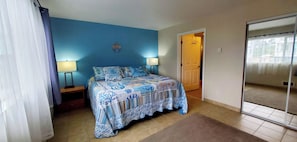 A bedroom with a bed, two bedside lamps, a door, and a mirror. - Condo #307 with beautiful sunset view from your balcony overlooking the ocean (Lincoln City)