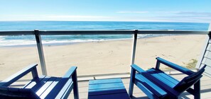 A beach view from a balcony with two blue chairs. - Condo #307 with beautiful sunset view from your balcony overlooking the ocean (Lincoln City)