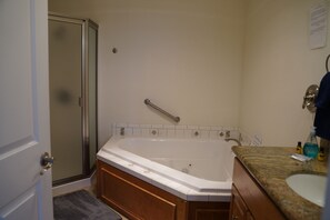 A bathroom with a bathtub, a shower, a vanity with a sink, and a towel rack. - Condo #307 with beautiful sunset view from your balcony overlooking the ocean (Lincoln City)