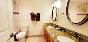 Une salle de bain avec des toilettes, un lavabo et un miroir.