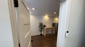 A modern kitchen with a wooden island, stainless steel refrigerator, and a potted plant.