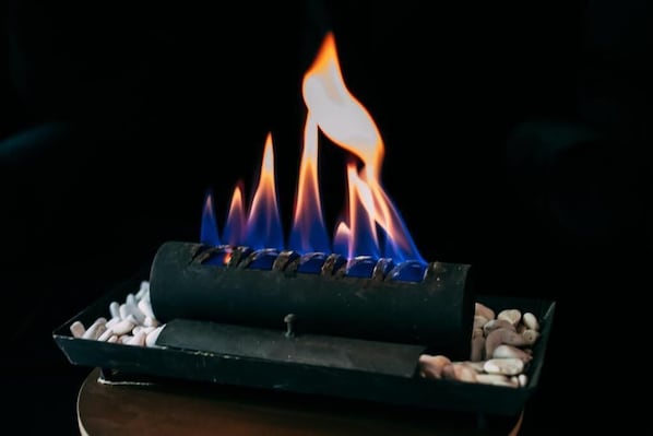 A close-up of a charcoal grill with burning coals and flames. - Bosocoso Hotel Boutique (Valle de Bravo)