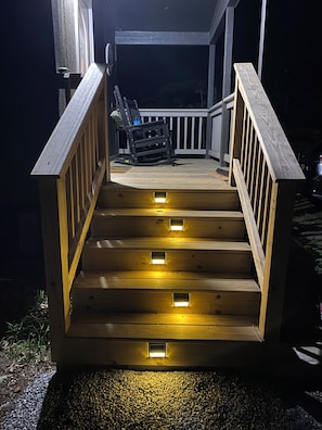 Eine HolztTreppe mit integrierter Beleuchtung, die zu einer Terrassenfläche führt.