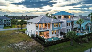 A large, two-story house with a balcony and a swimming pool. - Ocean Hammock Luxury with Pool, Game Room & Beach Access (Palm Coast)