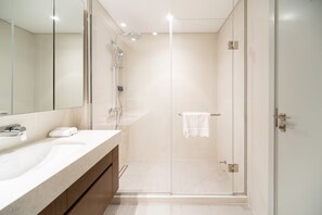 A modern bathroom with a glass shower enclosure, a large mirror, and a white sink. - SettlerHomes, Breathtaking View With Private Beach (Dubai)