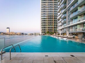 A swimming pool with a view of a high-rise building and a distant cityscape. - SettlerHomes, Breathtaking View With Private Beach (Dubai)